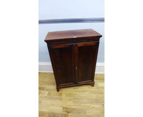 A 19th Century mahogany cabinet, having a moulded top above two panel doors enclosing shelves raised on bracket feet.  76 x 1