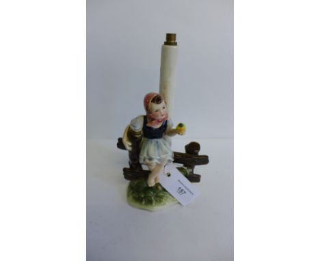 Royal Belvedere, Austrian pottery table lamp with a girl sat upon a gate with an apple in her hand, 25cm high