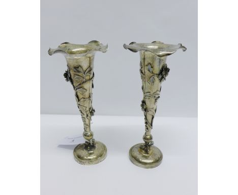 Pair of Chinese silver vases, with scalloped trumpet rims, applied with trailing flowers and foliage to the stems, on a scrol