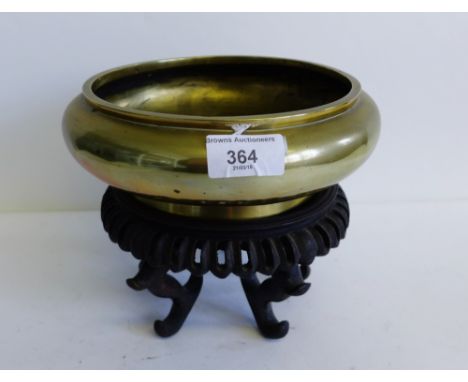 Chinese brass bowl of plain circular form, with seal mark to base, on hardwood stand, 22cm wide