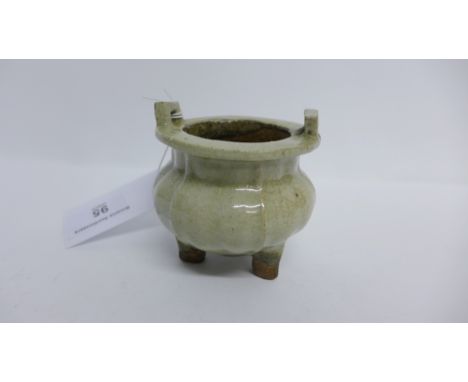 South East Asian green glazed twin handled pot of lobed form, raised on tripod supports.  7cm high