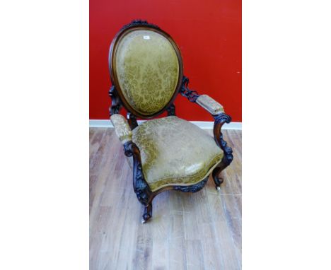 A late 19th Century carved mahogany parlour chair having a padded back support and arm rest above a stuff over seat, upholste