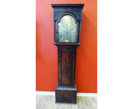 A 19th Century mahogany longcase clock with carved hood enclosing a domed brass face with Roman numerals, inscribed Mitchell 