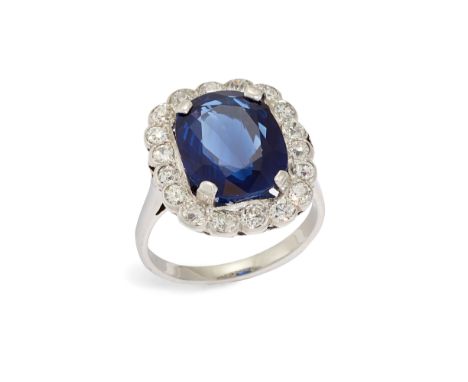 A 20th century sapphire and diamond cluster ring, composed of a claw set cushion shaped mixed-cut sapphire, measuring approxi
