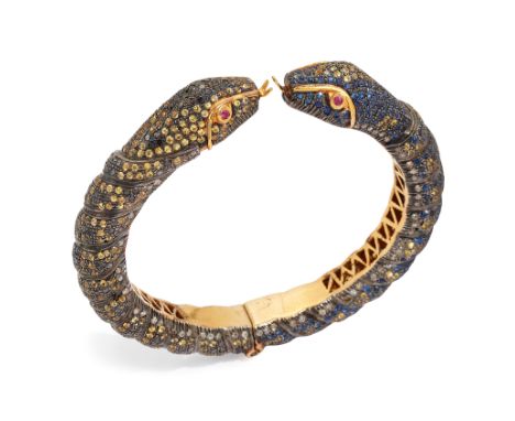 A silver snake form torque bangle,&nbsp;with confronting snake head terminals, both with ruby set eyes, to diamond, black dia