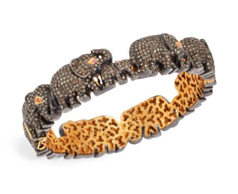 A silver diamond and ruby set hinged bangle,&nbsp;in the form of a herd of elephants, grain set throughout with single cut di
