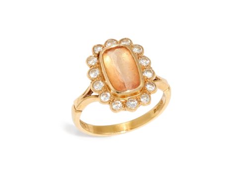 An 18ct gold topaz and diamond cluster ring,&nbsp;the cushion cut orange topaz in bezel setting, within brilliant cut diamond