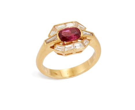 A ruby and diamond cluster ring, of geometric design, composed of a oval-mixed cut ruby, measuring approximately 6.4 x 4.9 x 