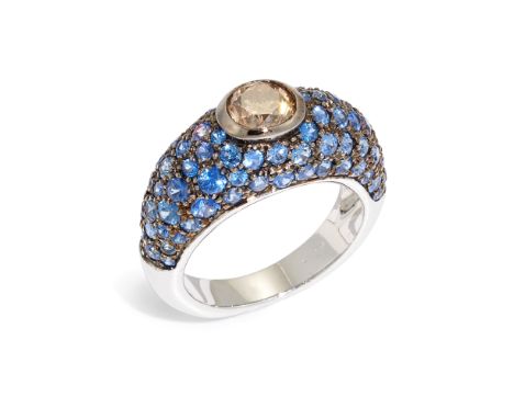 A brown diamond and sapphire bombé ring, the central oval-cut brown diamond in bezel setting, estimated as approximately 1.00