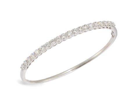 An 18ct white gold diamond bangle, the upper half set with round brilliant-cut diamonds, to plain lower half, Birmingham hall