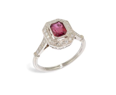 A ruby and diamond cluster ring, of geometric design, composed of a rectangular-cut ruby, measuring approximately 6 x 4.5 x 2