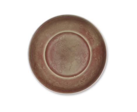 A RED-GLAZED INCISED 'CLOUDS AND CHILONG' SAUCER-DISHXuande six-character mark, KangxiRising from a slightly tapering foot to