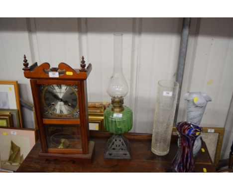 A cast iron base oil lamp, with green glass font