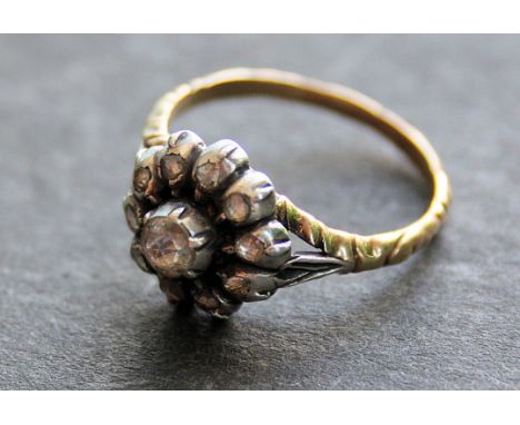 An 18ct gold and diamond continental ladies ring. The central rose cut old diamond, approx 0.20pts having flower head surroun