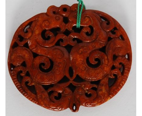 A 20th century Chinese oriental carved Jade roundel depicting dragons and foliage. 