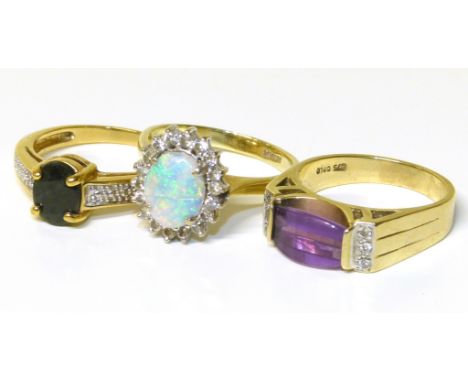 Three gem set dress rings, to include an amethyst and diamond dress ring, a sapphire and diamond dress ring, together with an