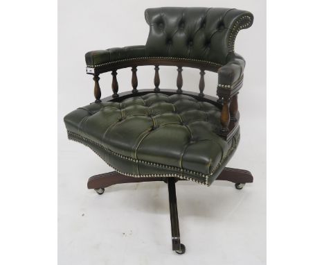 A 20th century mahogany and green leather button upholstered revolving captains desk chair Condition Report:Available upon re