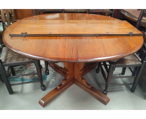 An Ercol elm oval extending dining table 