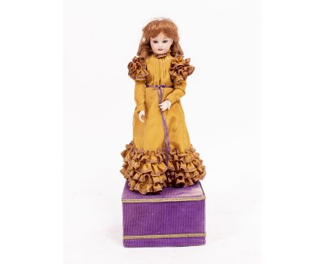 A BISQUE HEADED DOLL AUTOMATON 38cm high including the base
