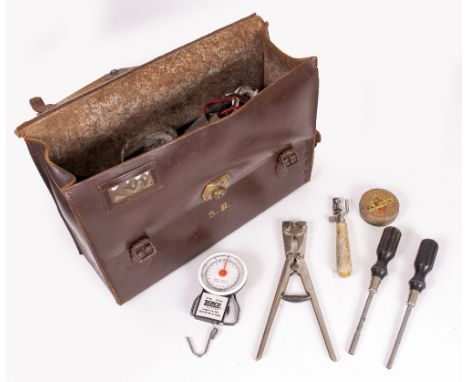 A LEATHER TYPEWRITER SERVICE ENGINEERS CASE with various tools and compartments within