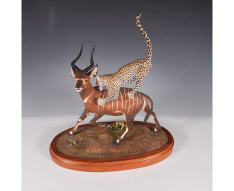 A rare and striking Louis Paul Jonas Studios wildlife sculpture depicting a leopard in mid-pounce, ambushing a bongo. This dy