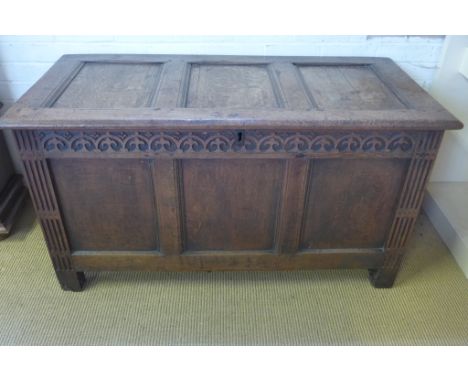 An 18th century oak coffer with three panel lift up lid and front with carved and fluted supports - 72cm x 130cm x 62cm 