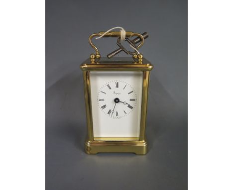 A modern brass carriage clock by Asprey of London with four glass bevelled panels and viewable escapement surmounted by swan 