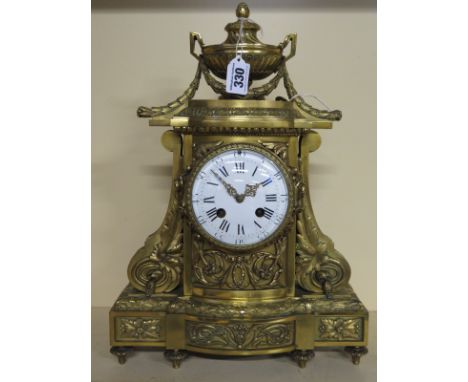 A 19th century French ormolu mantel clock by Vassy, circular dial with Roman numerals with elaborate carving and applied deco