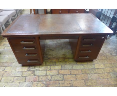 An Art Deco mahogany twin pedestal desk having tooled leather top with Grecian key border leading to twin banks of four gradu