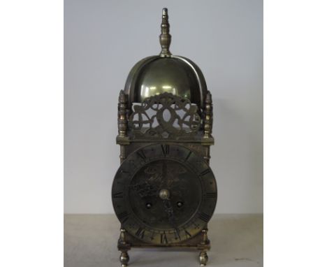 A brass lantern type striking mantle clock with a French movement - Height 32cm