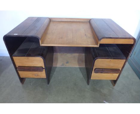 An Art Deco hardwood desk with a sloping centre above a kneehole and three drawers - 80cm x Width 138cm x Depth 69cm