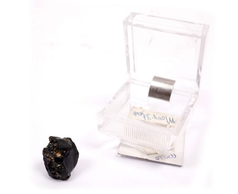 The geological collection of NASA scientist Charles M. Grant. A black rock sample (4.1 grammes) in sample box marked 'Apollo 