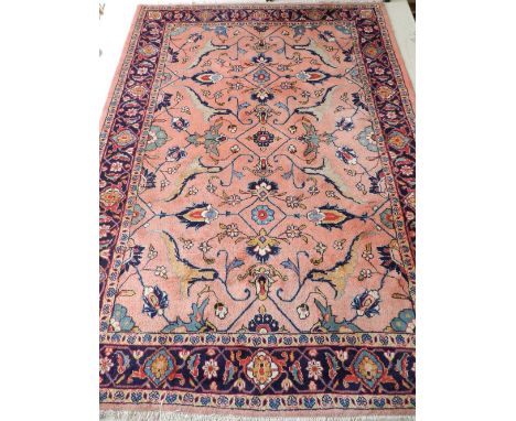 A pale pink ground Khorasan carpet, decorated with stylised foliage to centre, within floral borders, fringed L: 240cm, W: 18