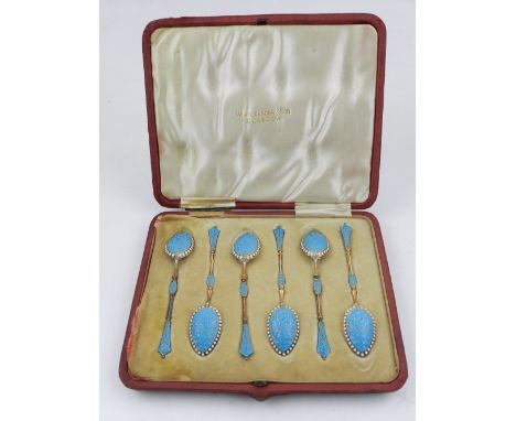 A set of six gilt metal and enamel spoons, decorated in blue and white enamel, boxed. 
