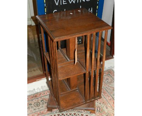 An early 20th century oak revolving bookcase, raised on a square stepped base and bracket feet. H: 83cm W: 45cm D: 45cm