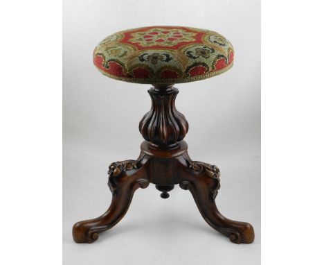 A 19th century French walnut piano stool, with baluster shaped column, raised on carved cabriole legs, tapestry upholstered s