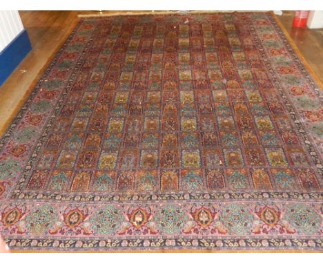 A Indian part silk carpet, decorated with rows of rectangular panels designed with scrolling foliage, within many borders, fr