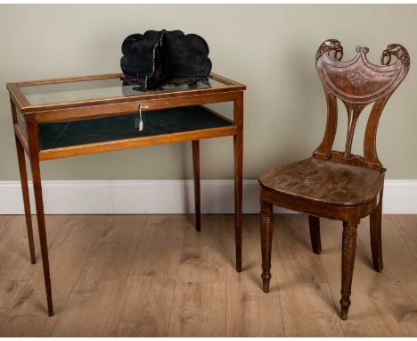 A 19th century mahogany hall chair with shield shaped back decorated with eagles and the remains of a painted crest; together