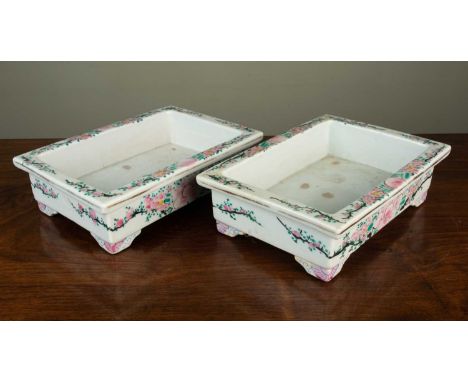 A pair of Oriental porcelain rectangular shallow jardinieres, each decorated with prunus blossom and on bracket feet, 25cm wi