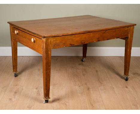 A pine kitchen table on tapering supports and castors, 105cm deep x 137cm long x 78cm highSome surface marks and scratches al