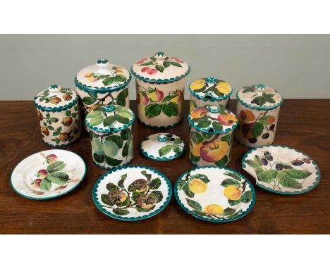 A group of Wemyss ware jars, decorated with various fruit, together with a spare jar lid and four stands, the largest jar 15.