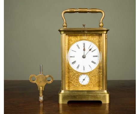 A brass cased carriage clock, the circular enameled dial within an engraved ornamented panel with alarm dial beneath and with