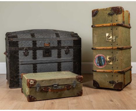 An old iron-bound dome topped trunk with decoratively fitted interior and leather handles to the side, 83cm wide; together wi