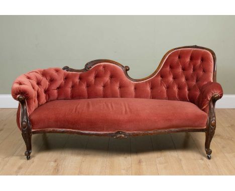 A Victorian pink Draylon upholstered button back chaise longue with carved supports to the front and serpentine seat, 180cm w