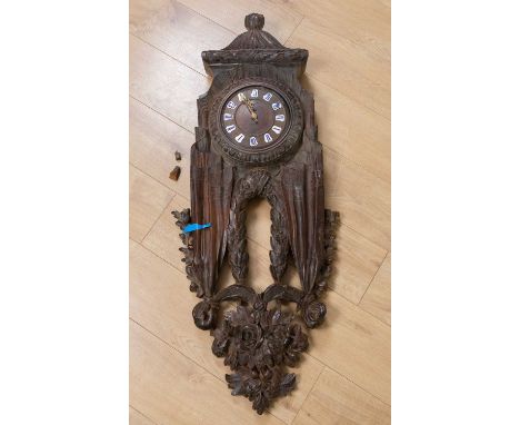 A late 19th/early 20th century carved continental walnut hanging time piece, decorated with swags of fuit and cloth around th