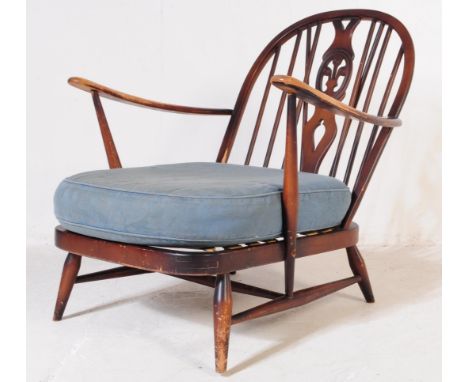 Ercol Furniture - A mid 20th century beech and elm Ercol Fleur De Lys pattern Windsor armchair. the chair having shaped elbow