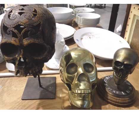 Polished brass skull, a carved skull on stand and a bronzed skull, largest H: 27 cm, (3). P&amp;P Group 3 (£25+VAT for the fi