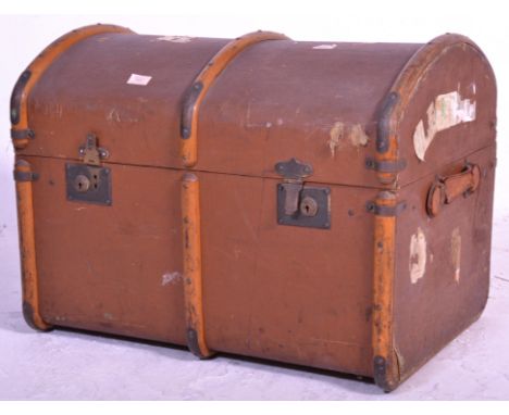 A vintage early 20th Century domed lid canvas trunk with wooden binding, retaining brown paintwork with initials MB painted t