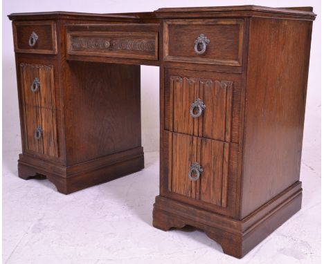 A mid century oak twin pedestal drop centre office desk. Each pedestal raised on plinth base with a series of drawers. The dr