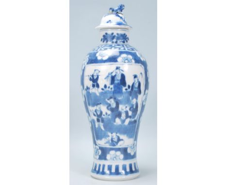 A 19th Century Chinese lidded vase of baluster form having a hand painted blue and white prunus pattern ground, with panels t